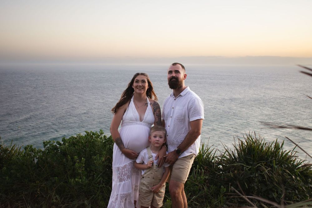 Newcastle maternity photographer capturing mother-to-be with husband and toddler at Redhead Bluff