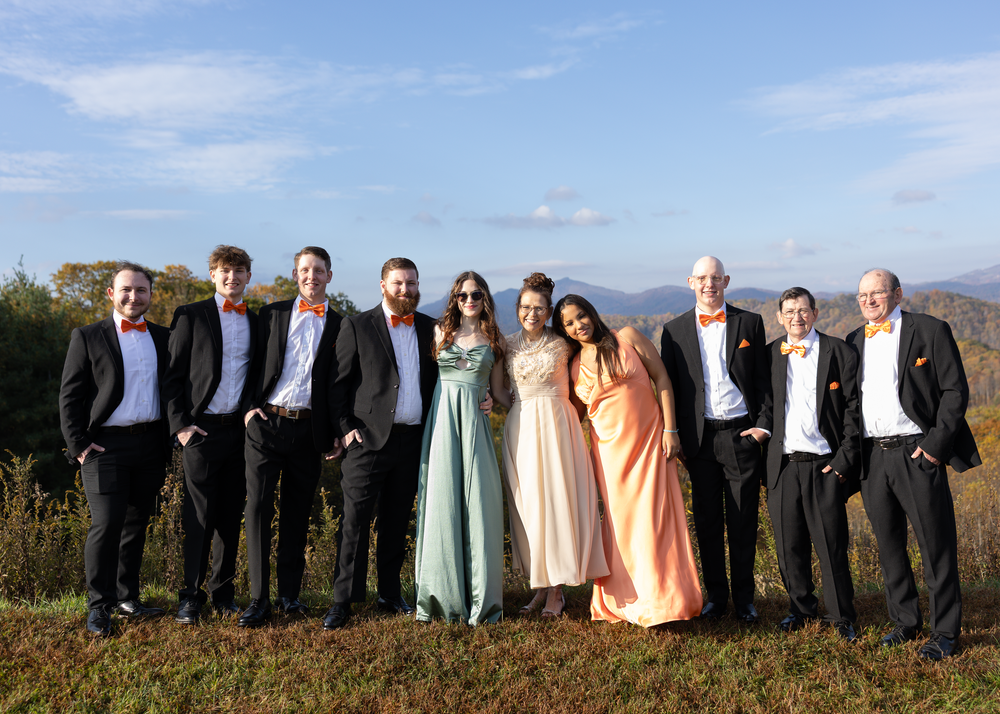Wedding party group photo with mountains and fall foliage in the background.