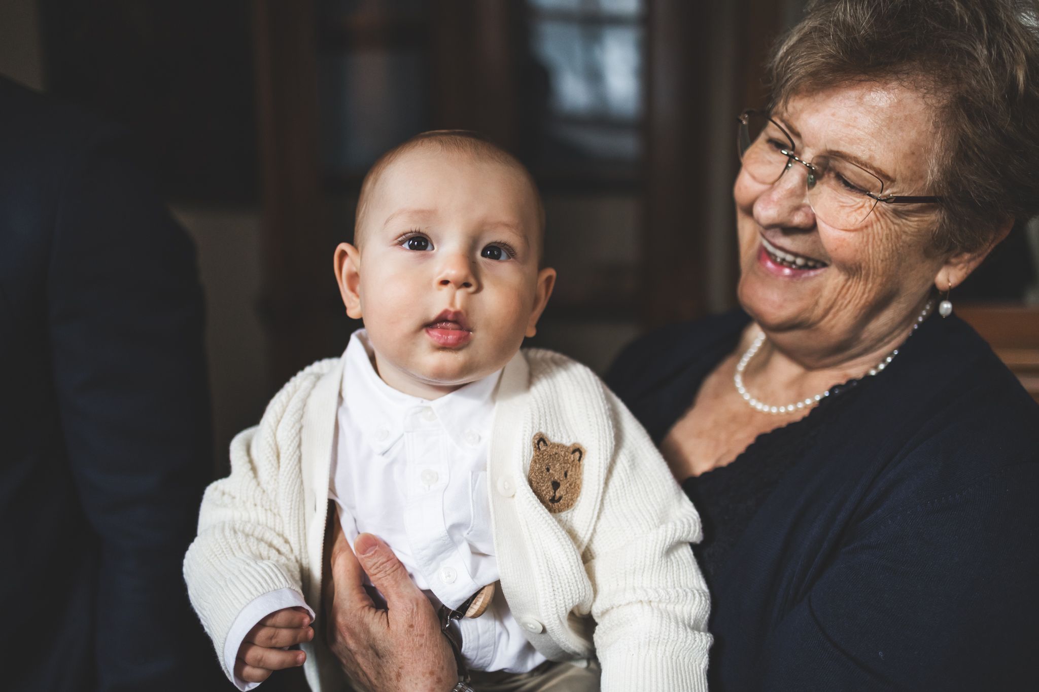 A series of candid moments showing a baby and elderly person interacting and sharing joyful expressions together.