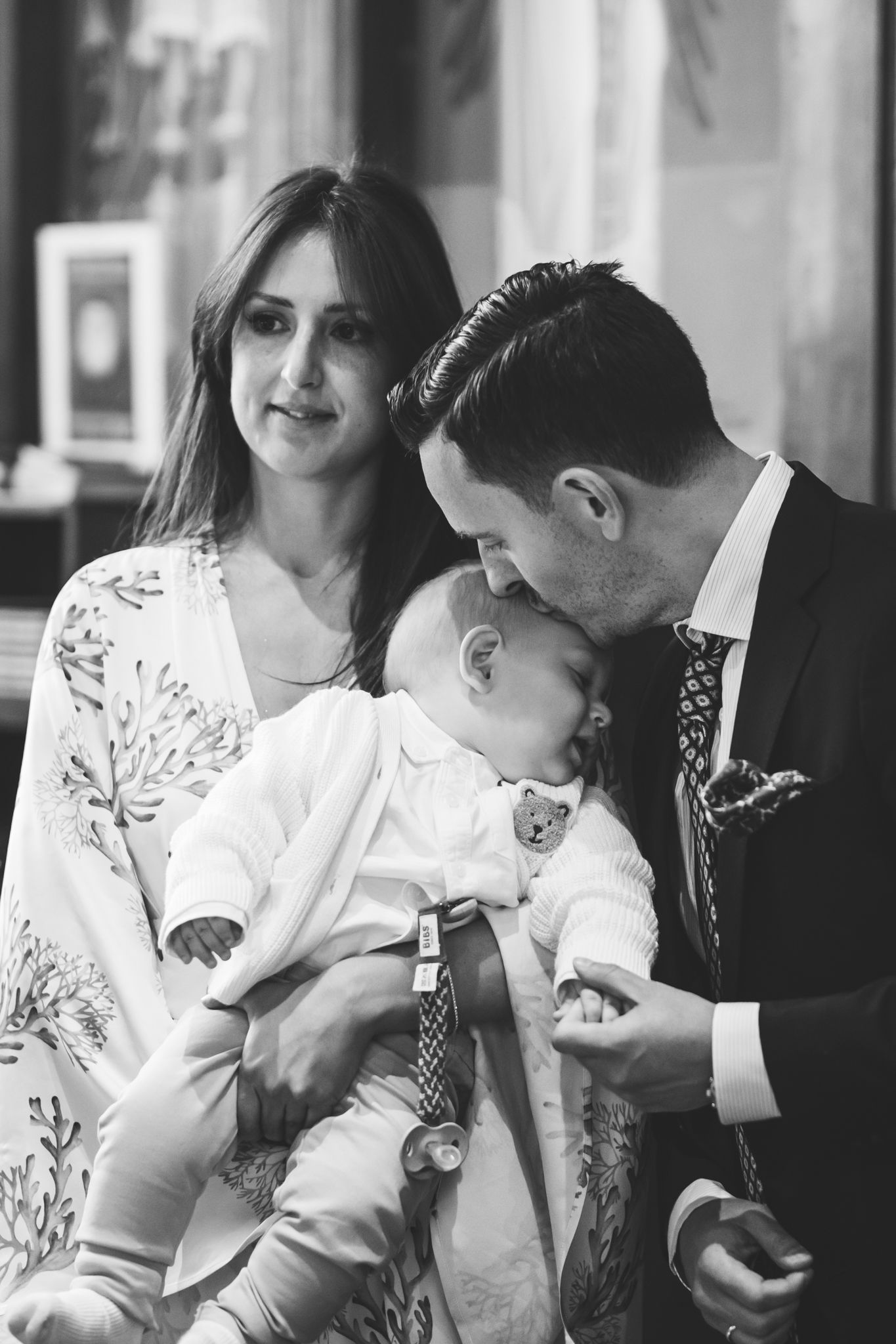 A black and white photo series shows tender moments between a couple wearing white as they embrace and interact.