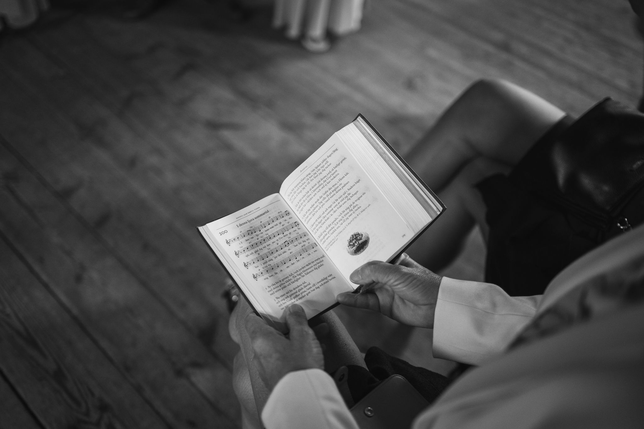 Black and white photo of people reading books together in a group setting.