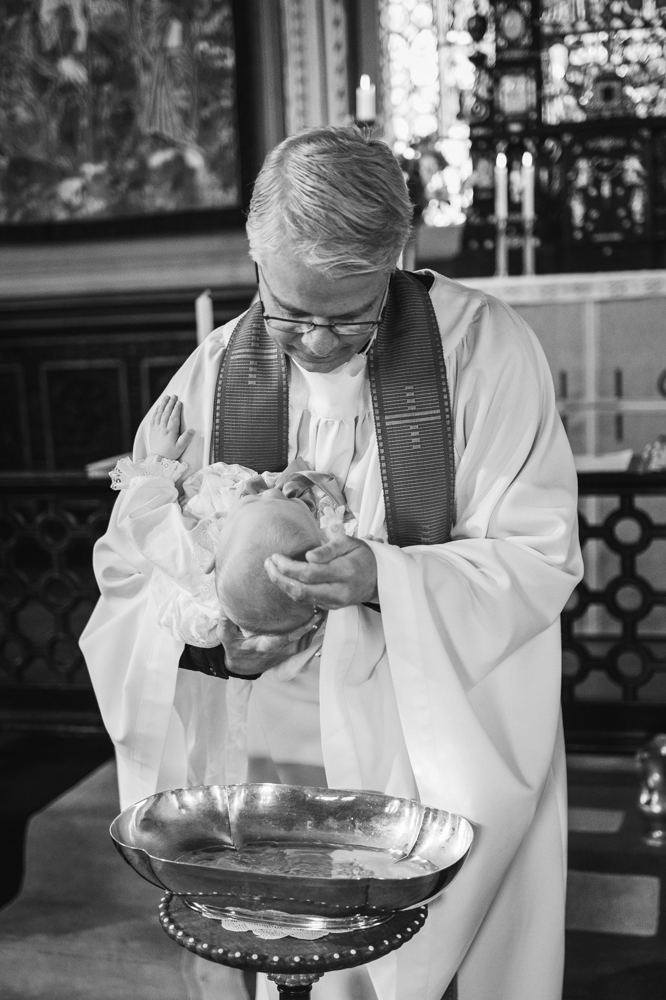 A person in a white lab coat examines a glass bowl in a sequence of black and white photographs.