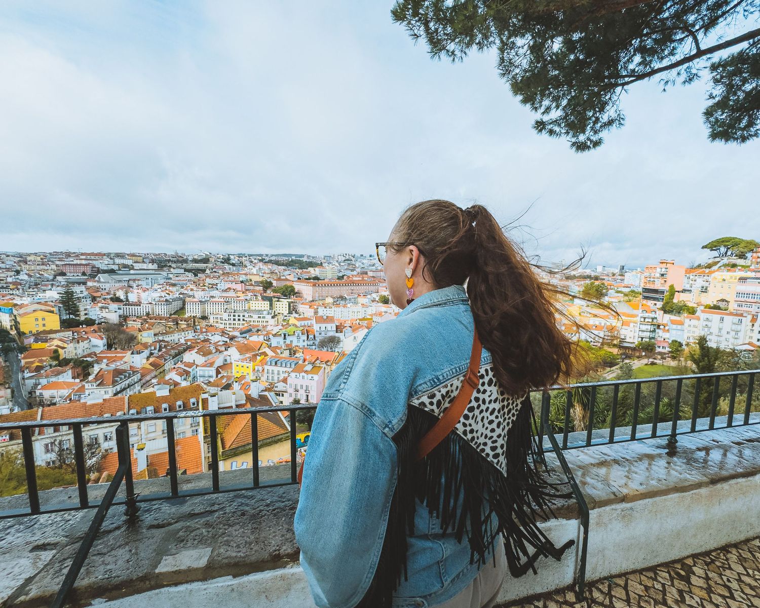 Scenic overlook of orange-roofed buildings in Lisbon cityscape.