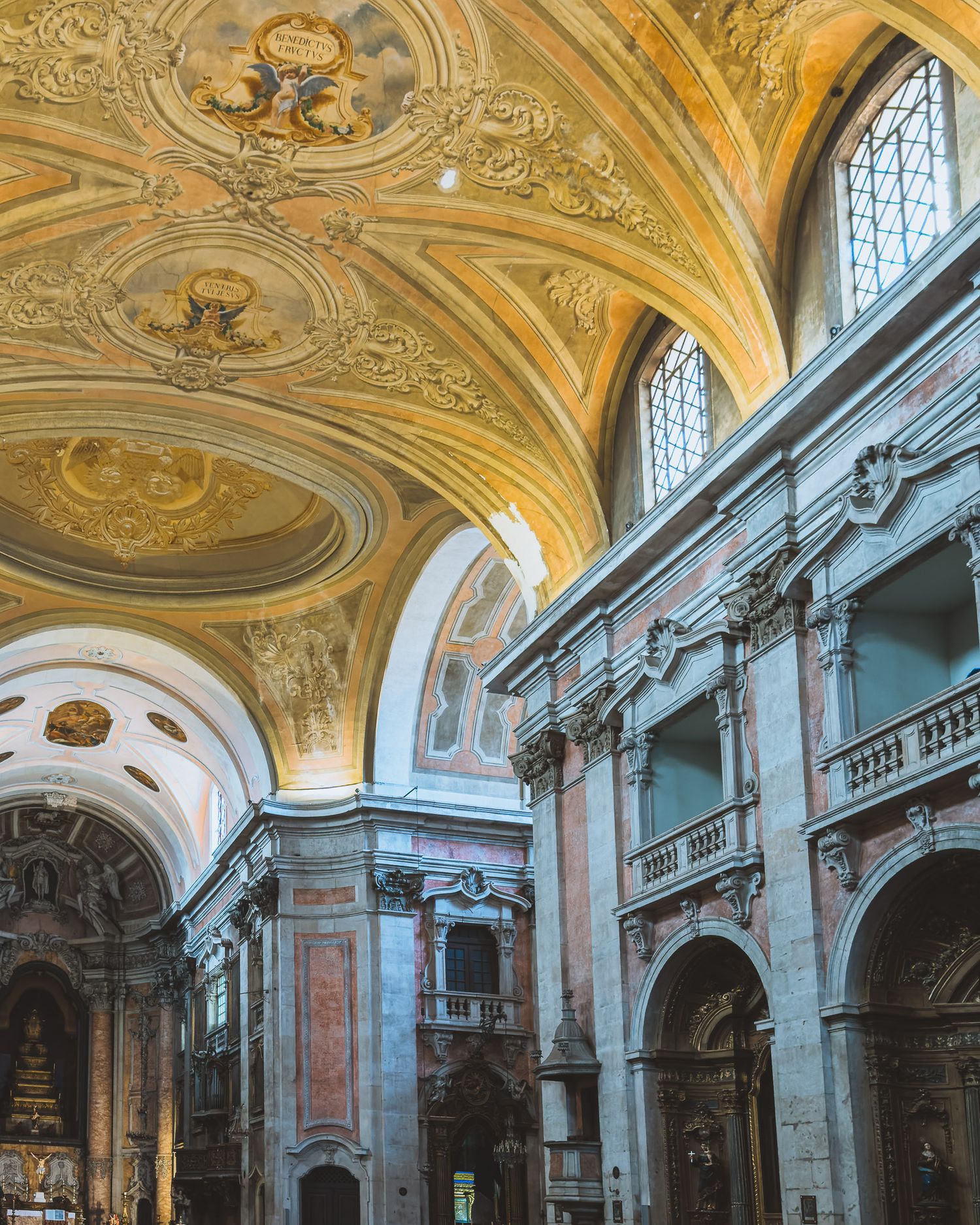 Panoramic view of a baroque church interior showing ornate ceiling frescoes and architectural details.