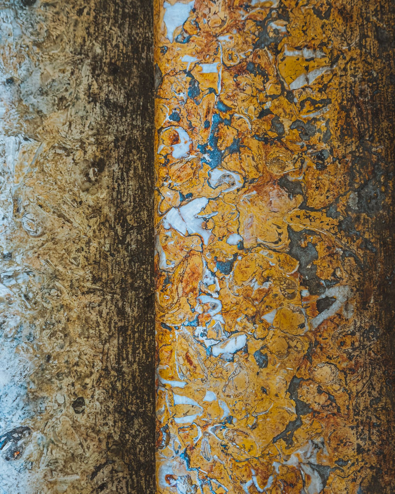 Textured wall surface showing weathered orange paint and exposed concrete patterns.
