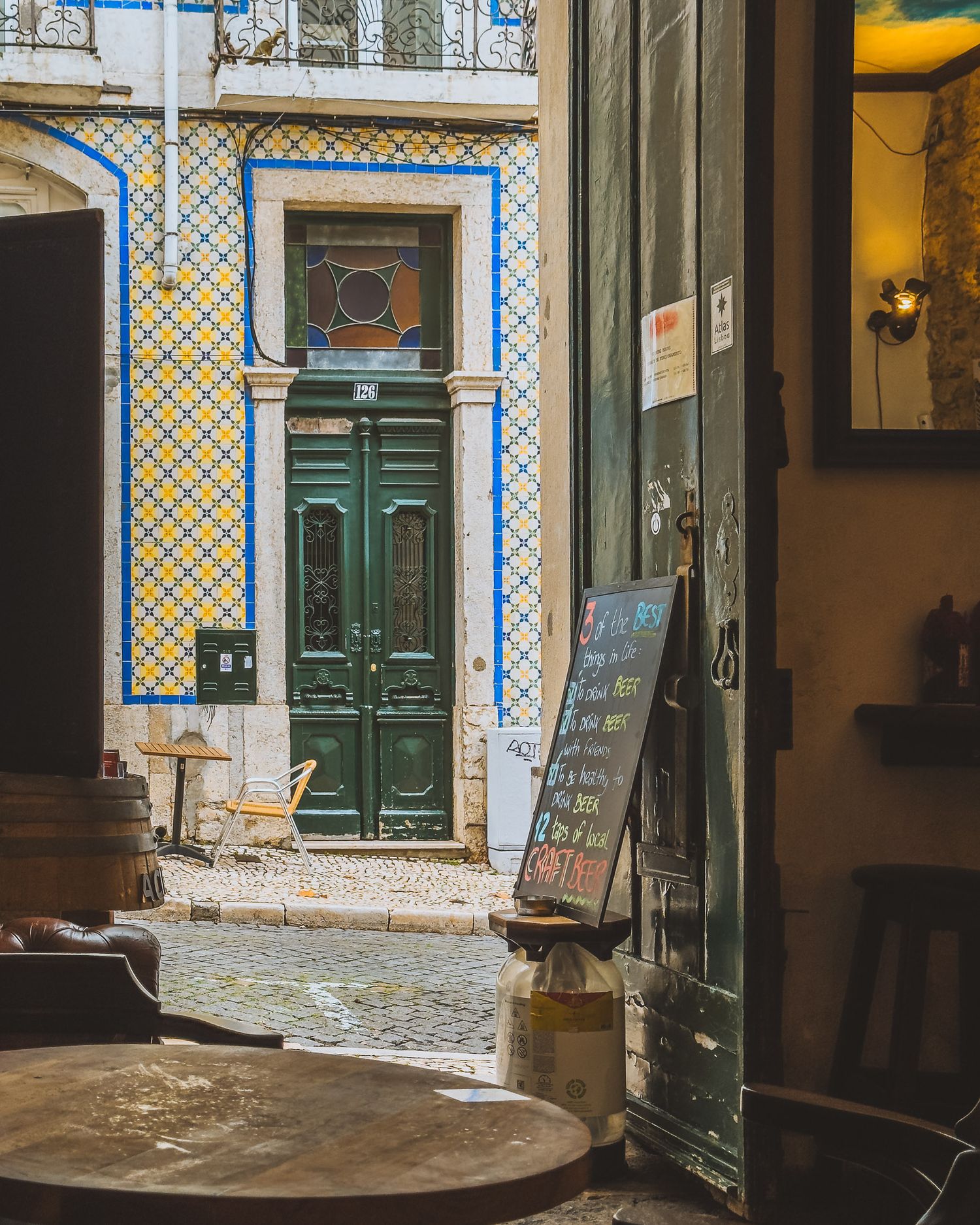 Traditional Portuguese building entrance with decorative blue tiles and green doors.