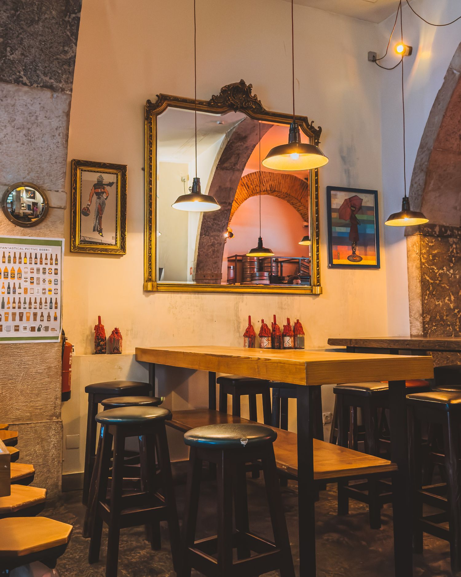 Cozy pub interior with wooden bar stools and vintage decor on stone walls.