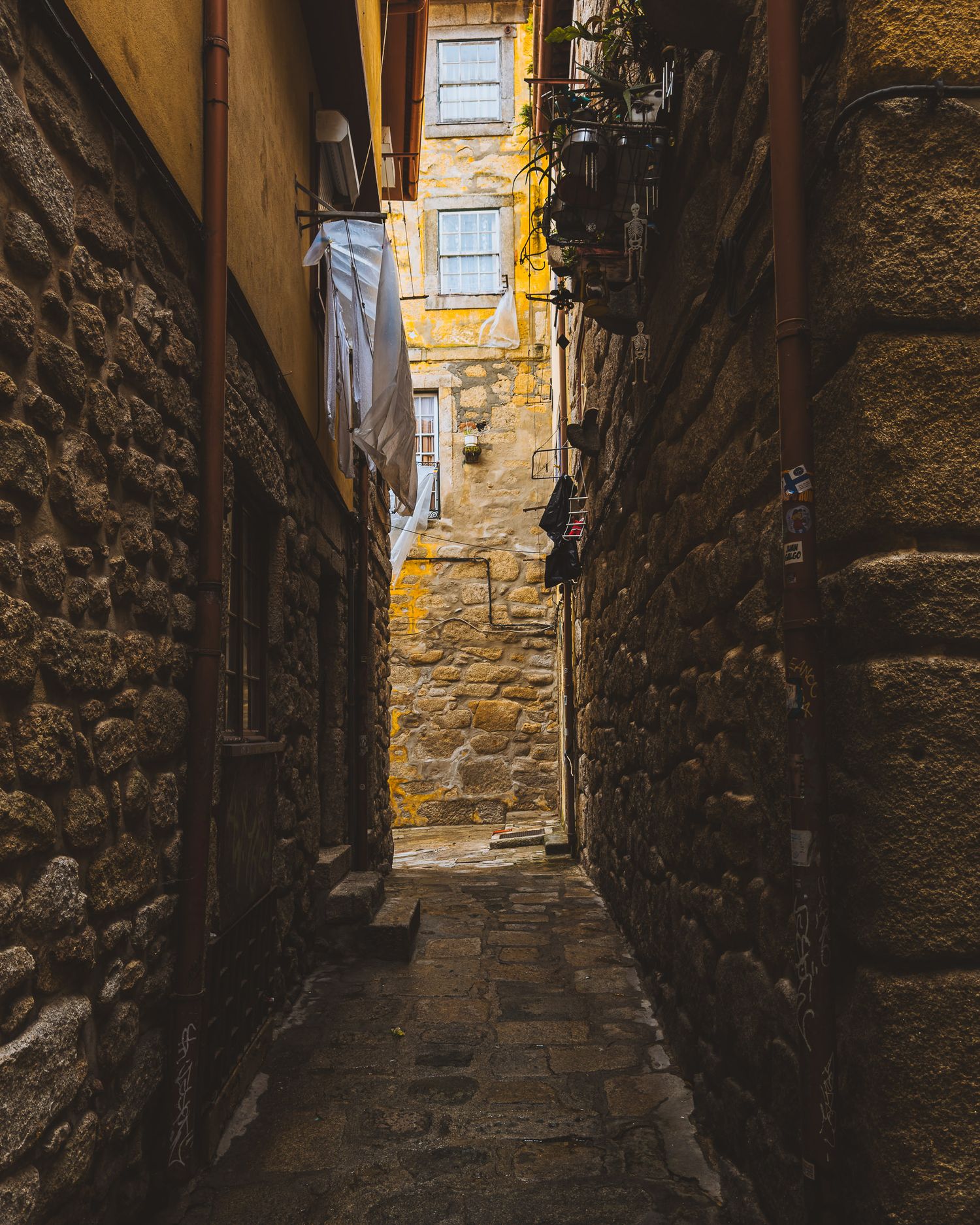 Atmospheric narrow alley with stone walls and steps leading upward in golden light.