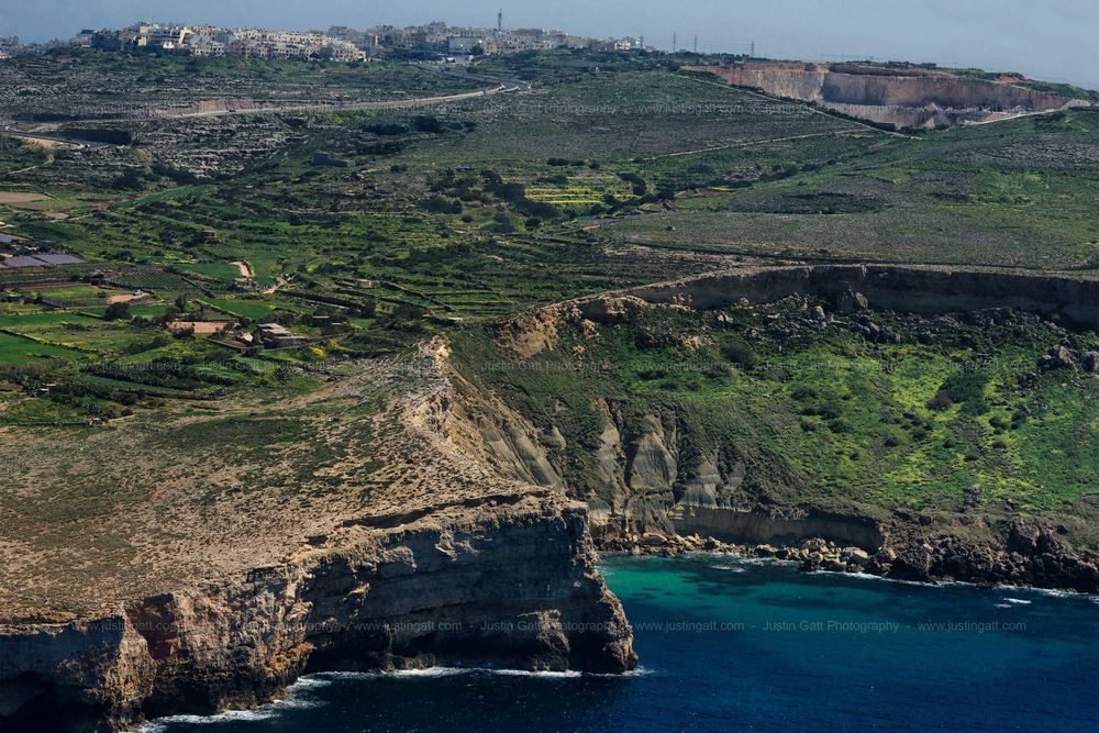 Coastal panorama showing cliffs, rural landscape and historic buildings along Mediterranean shoreline.