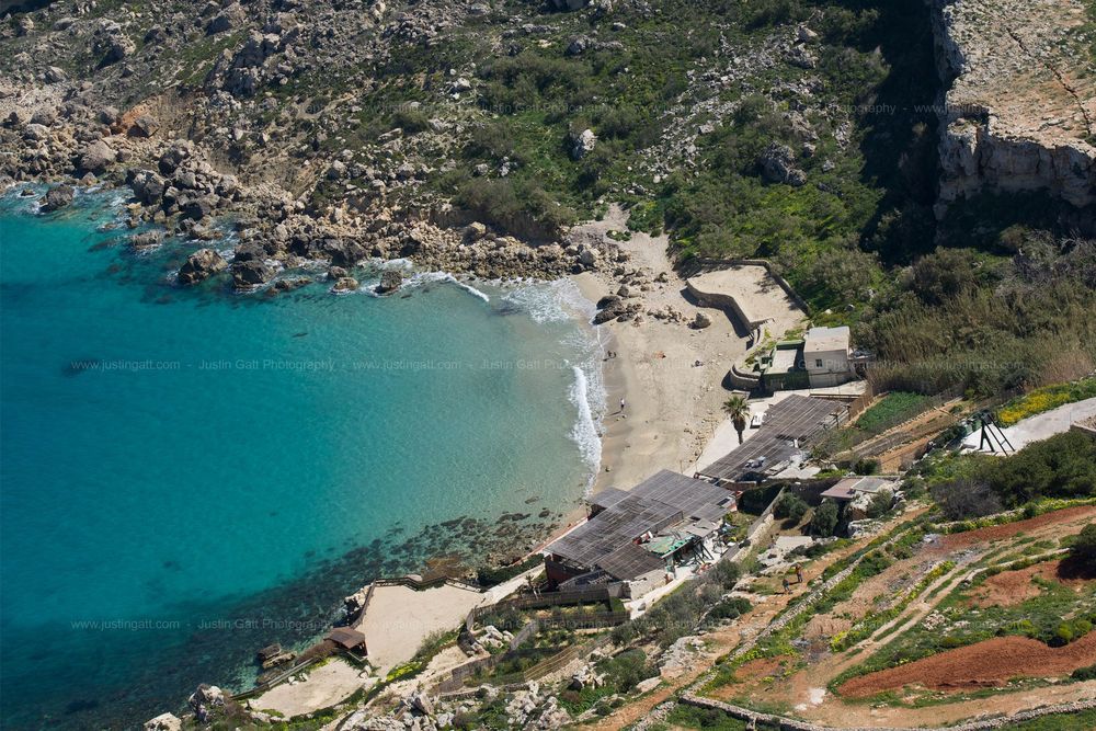 Aerial view of rugged Mediterranean coastline with turquoise waters and rocky cliffs.
