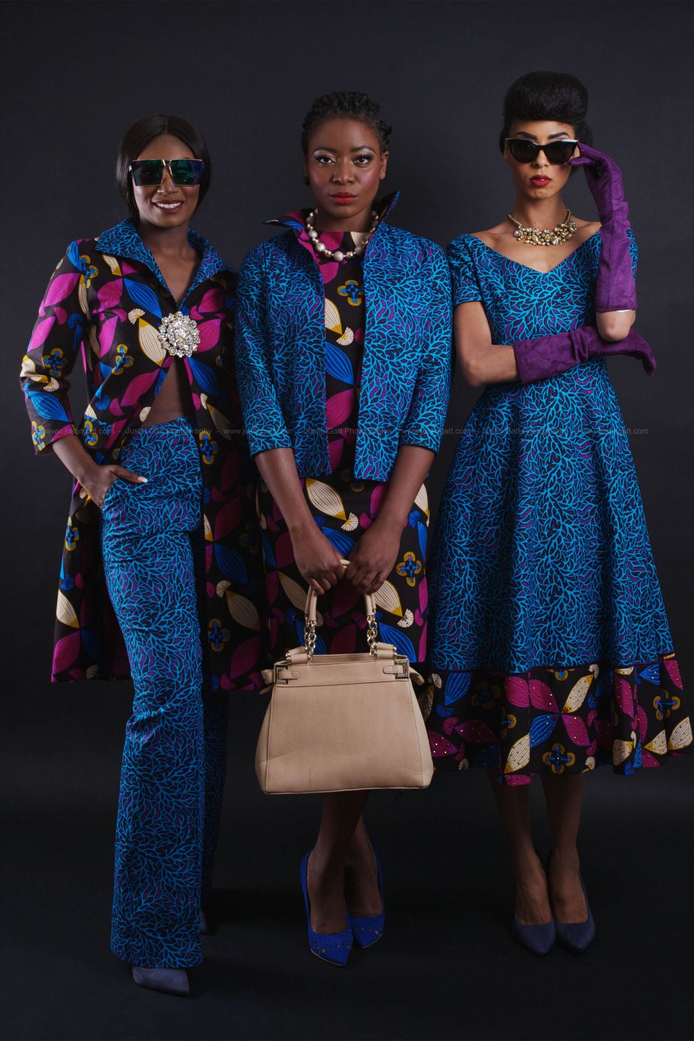 Group wearing coordinated blue and floral print outfits pose with accessories in studio lighting.