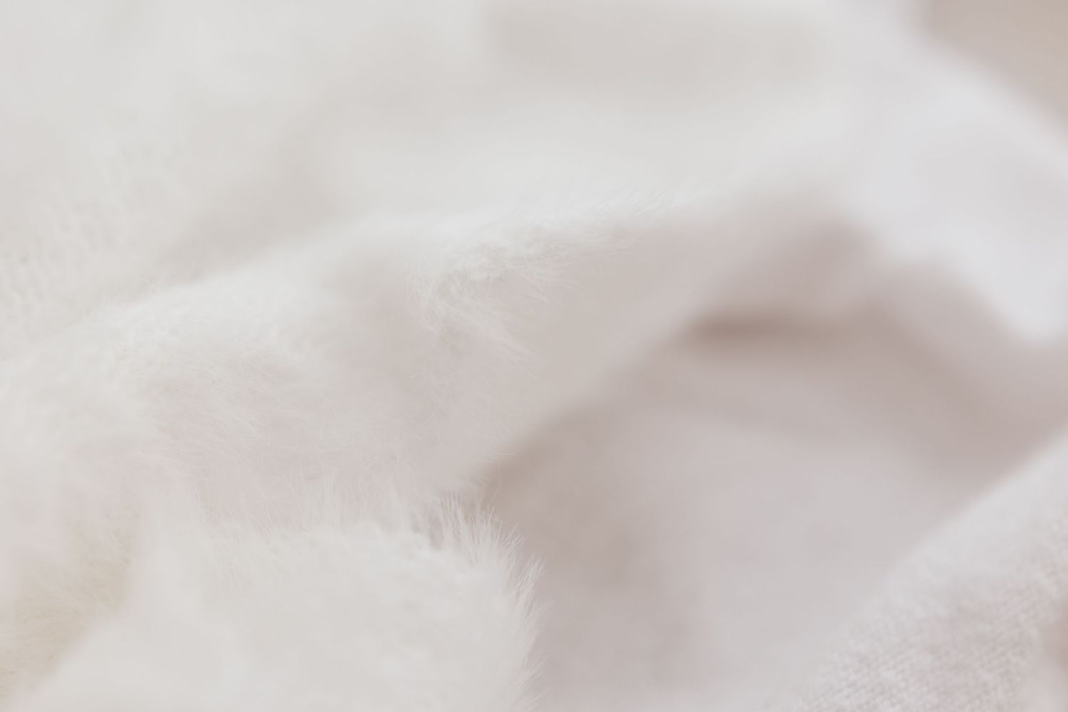 Close-up texture of soft white fluffy fabric or fur.