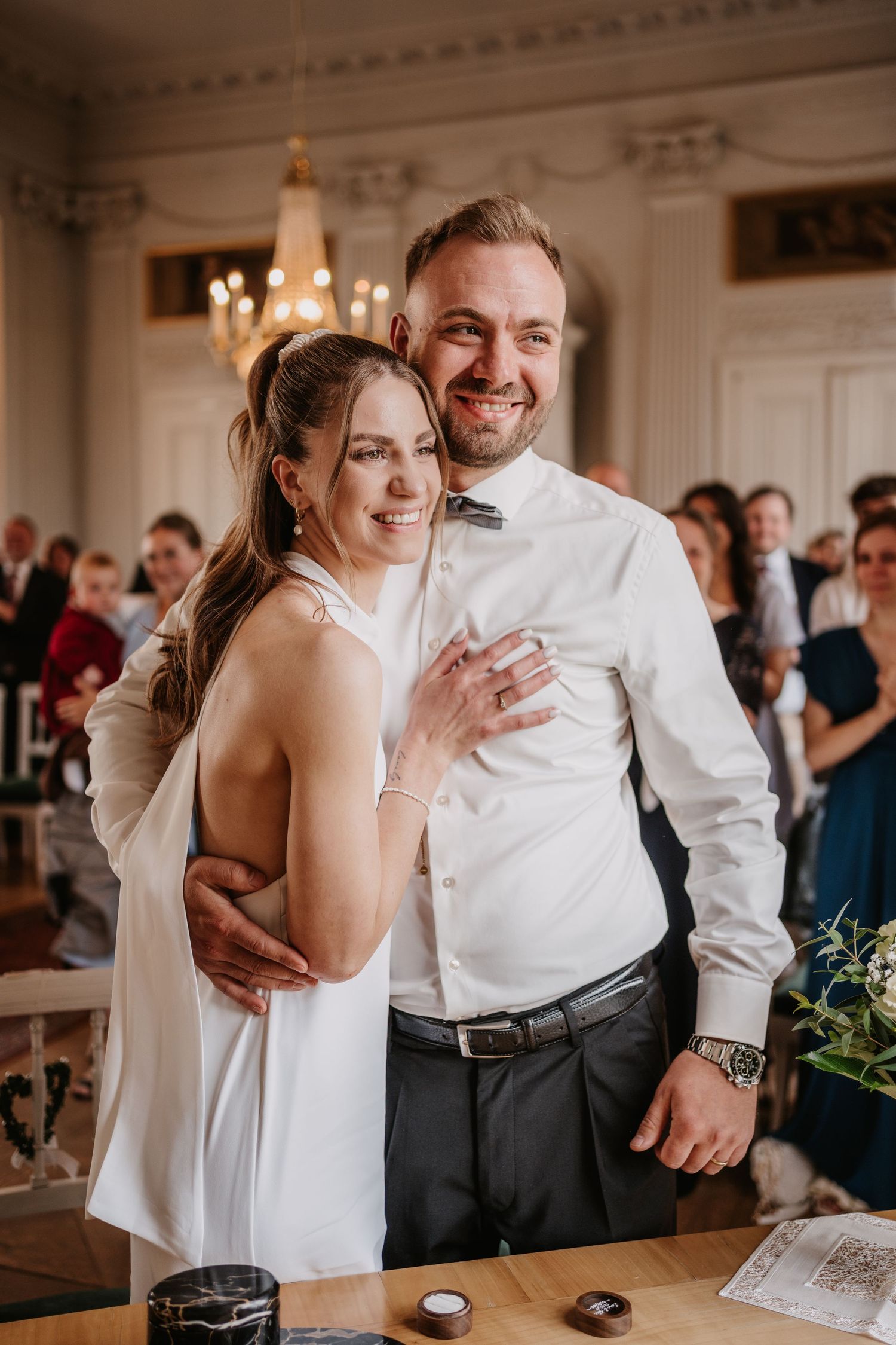 A joyful wedding reception dance moment between a bride in white and her dance partner in a bright indoor venue.