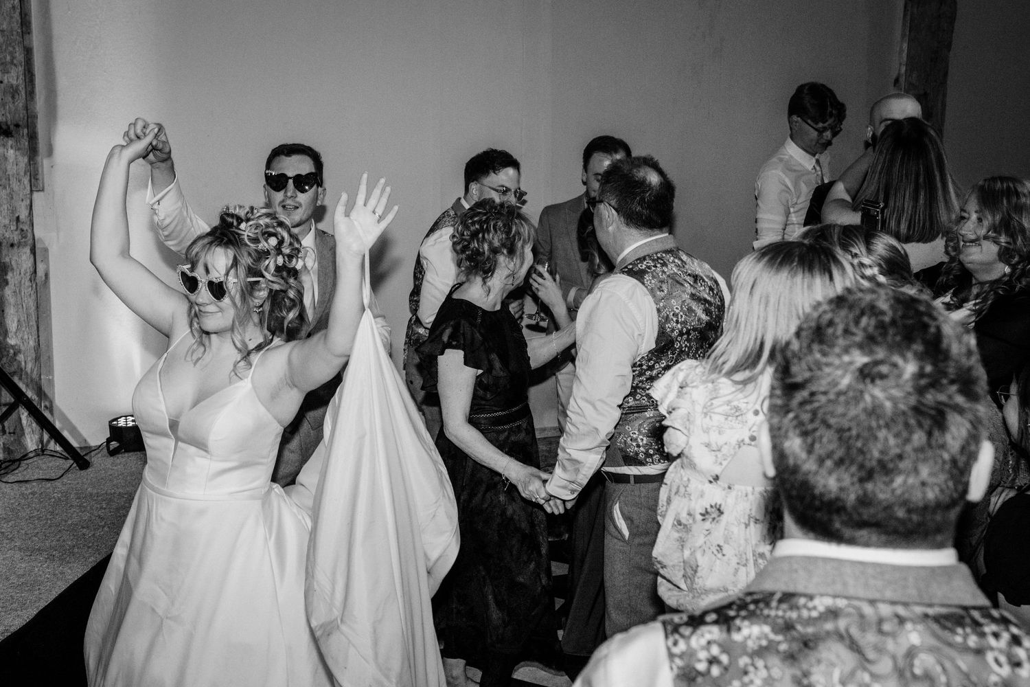 Black and white photo montage showing candid dance floor moments at a wedding reception with people dancing and celebrating.