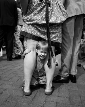 Echter Reportage-Moment: Ein verspielter Augenblick, wenn die Welt unter Mamas Kleid zum Versteck wird. Pur, emotional & ungestellt.