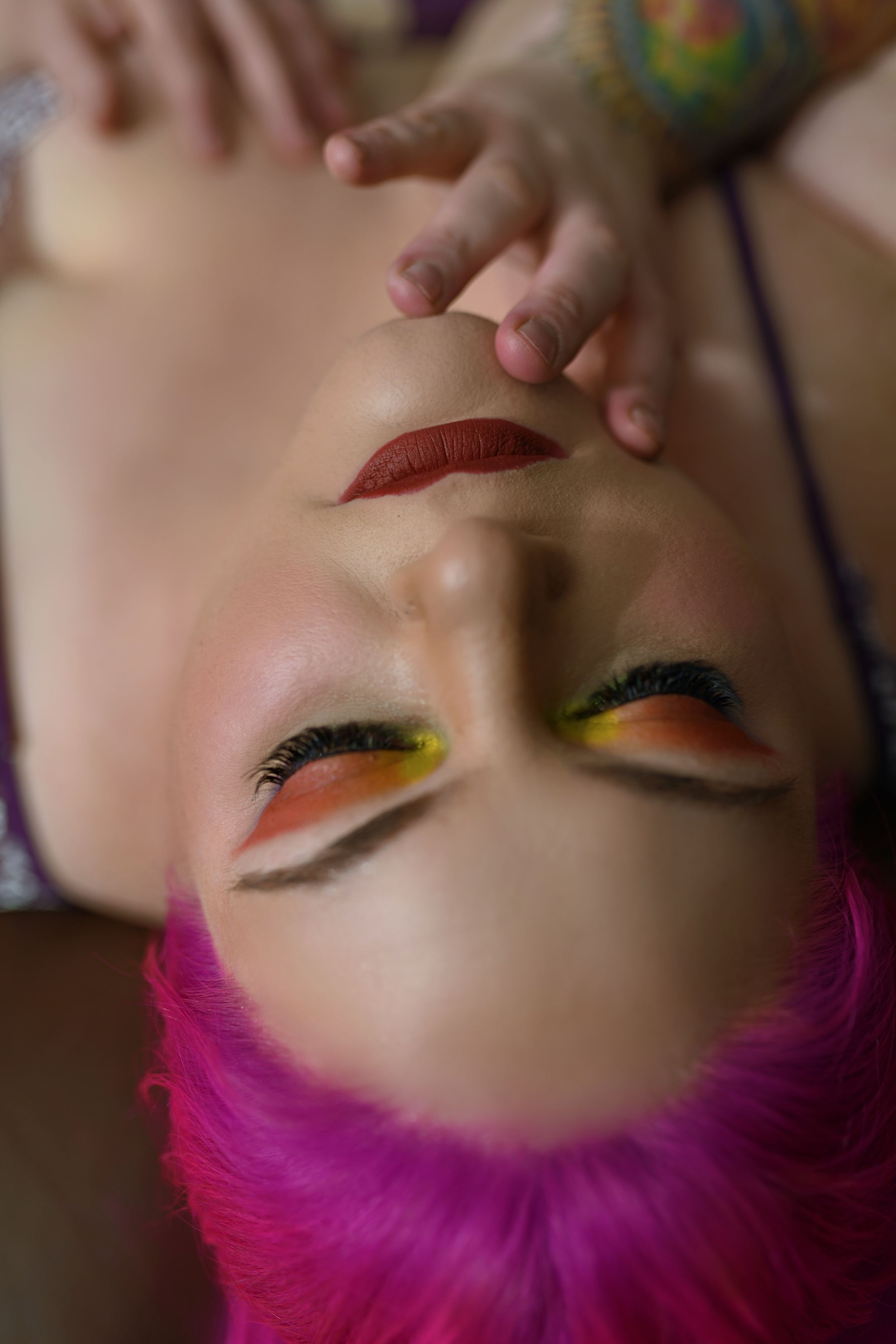 Close-up shots of colorful eye makeup looks with bright yellow eyeshadow and vibrant pink hair in progressive stages.