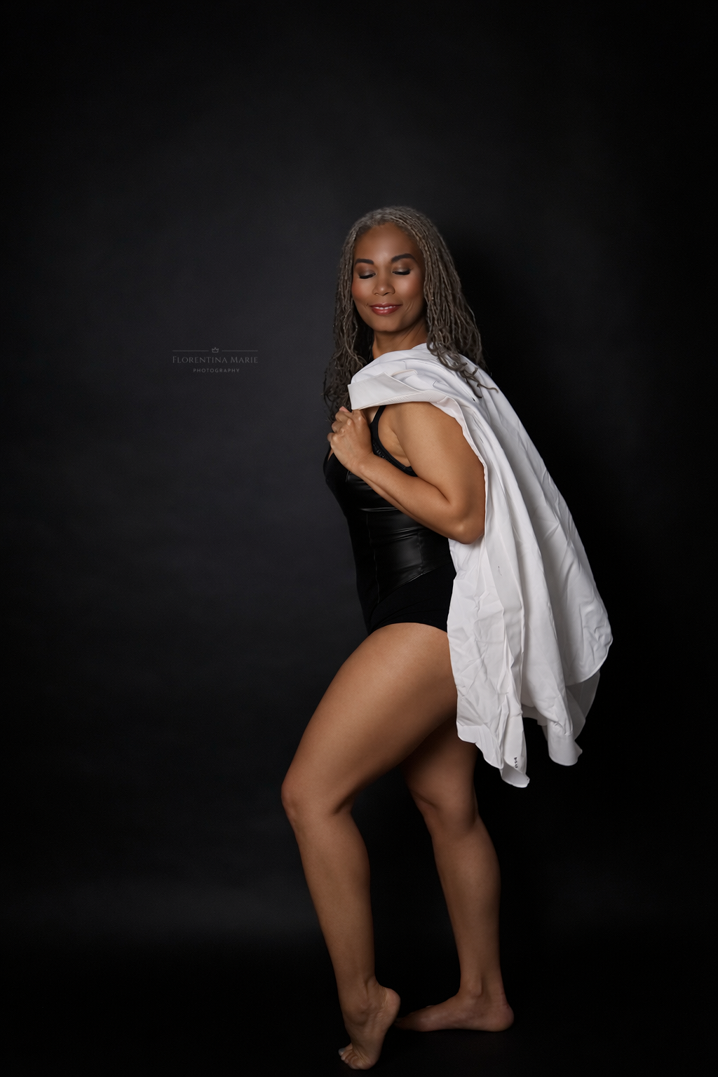 Artistic black and white photo series showing sensual poses against dark background with white fabric draping.