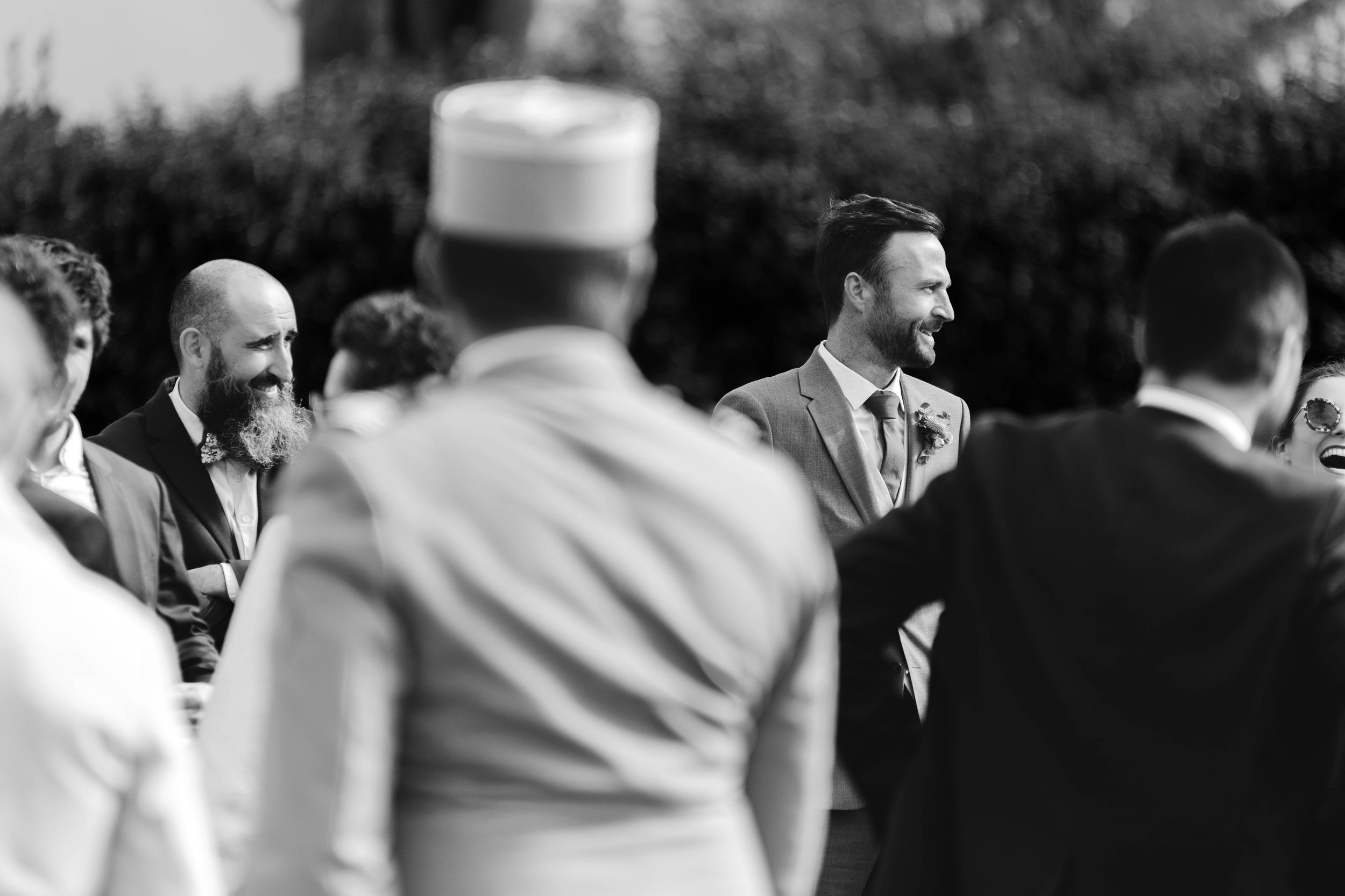 Invités réunis lors d’une cérémonie de mariage en extérieur en Bretagne, photo en noir et blanc.