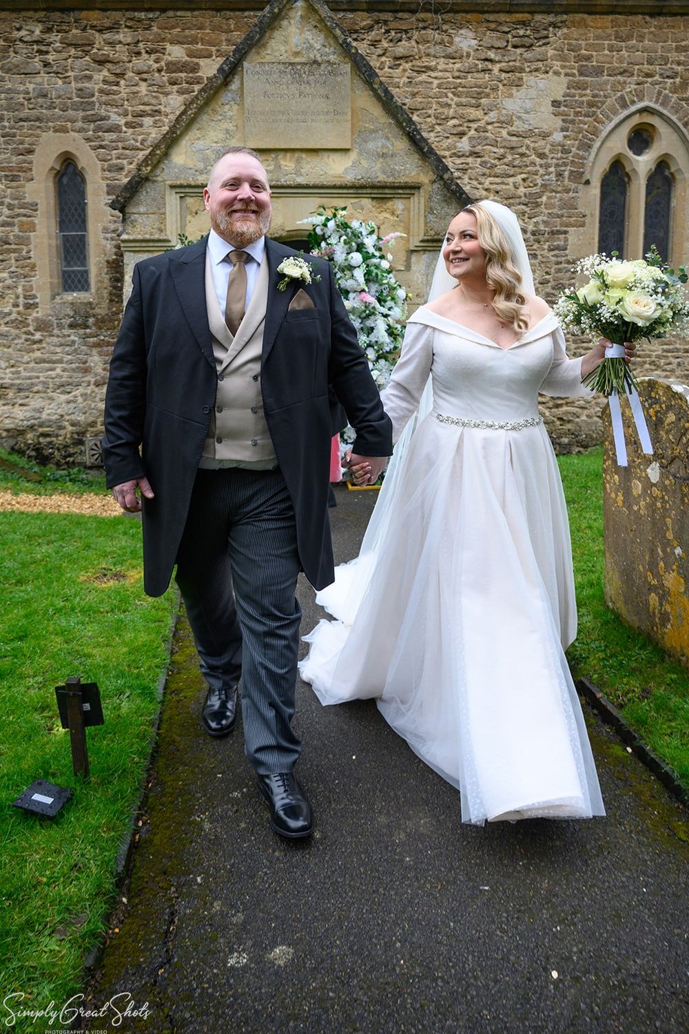 Bride and groom walking away from St Andrews C of E Church after wedding ceremony in Oxfordshire