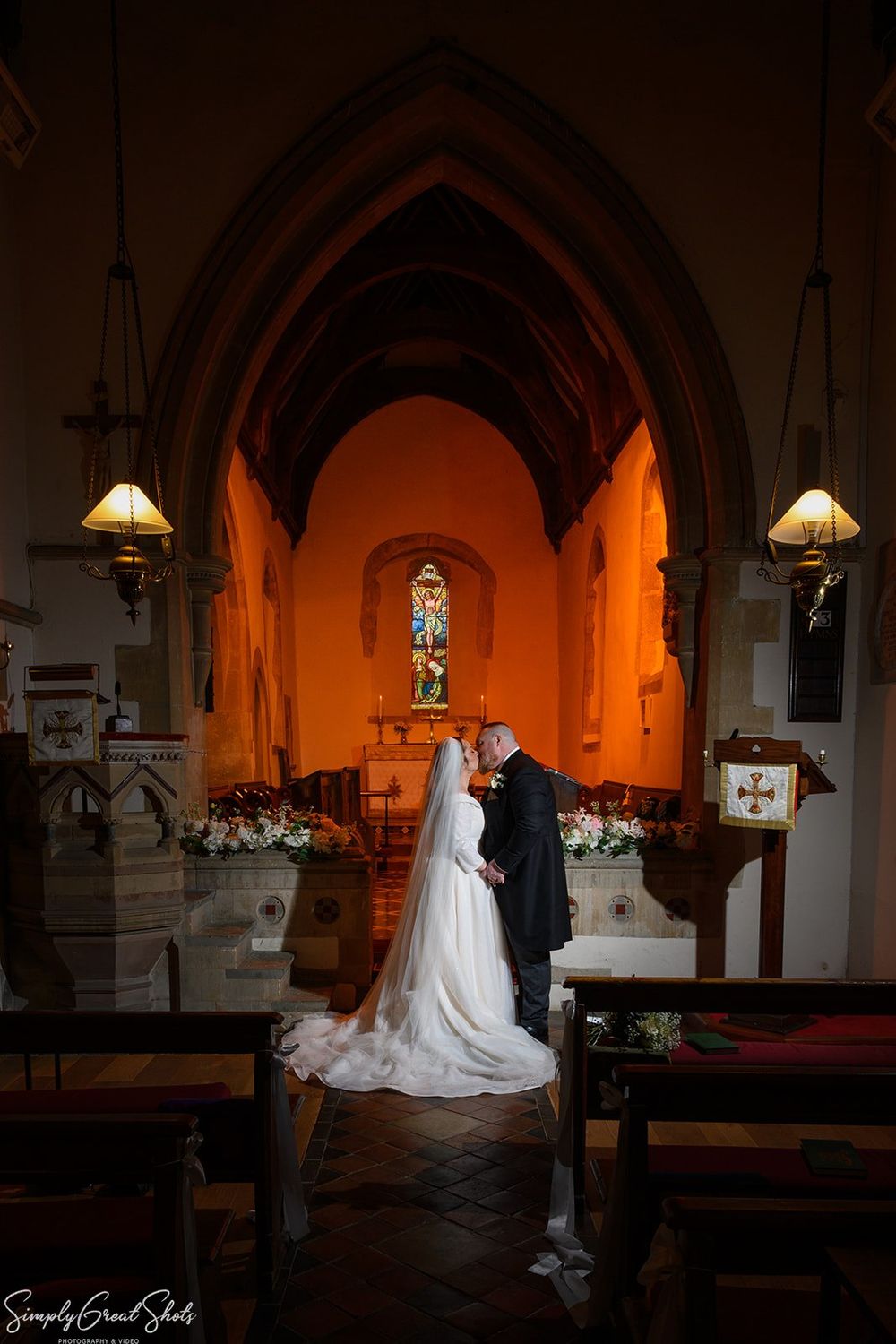 Bride and groom romantic portrait with warm orange lighting at St Andrews Church, Oxfordshire