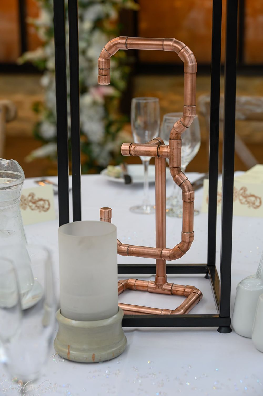 Handcrafted copper pipe table numbers made by groom at voco Oxford Thames wedding reception