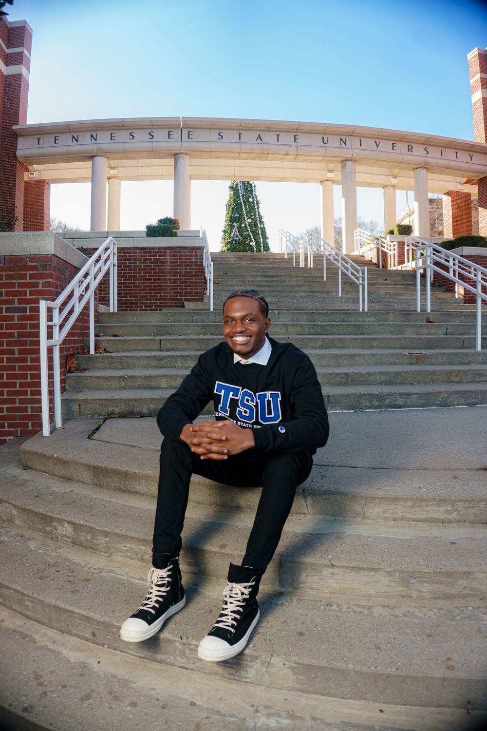 A series of connected photos showing someone sitting casually on concrete steps wearing a TSU sweatshirt and sneakers.