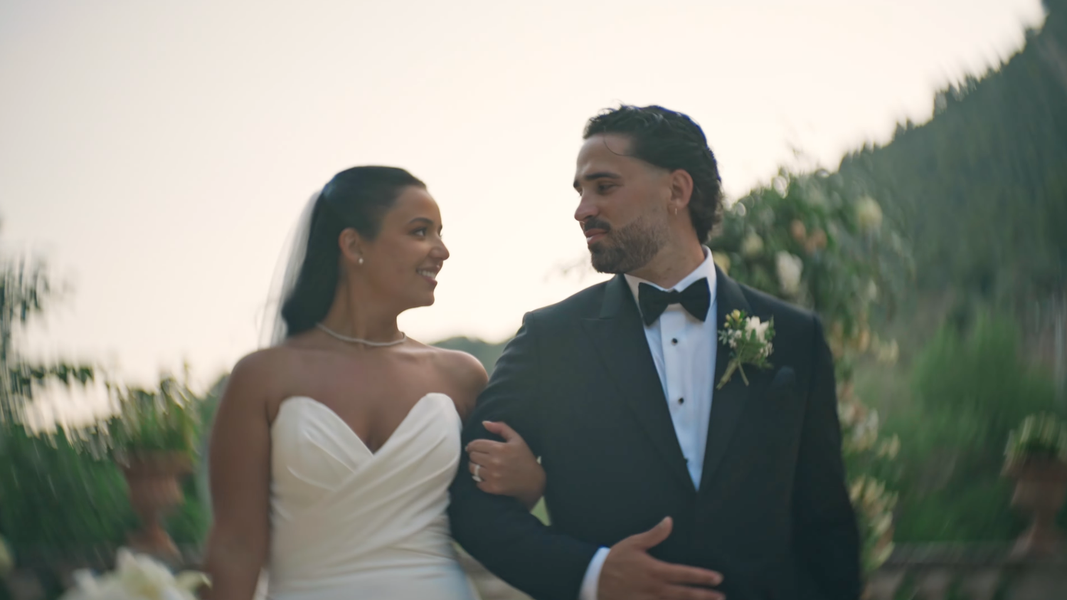 wedding video screenshot from Finca Comassema. a wedding couple going through the ceremony isle holding hands