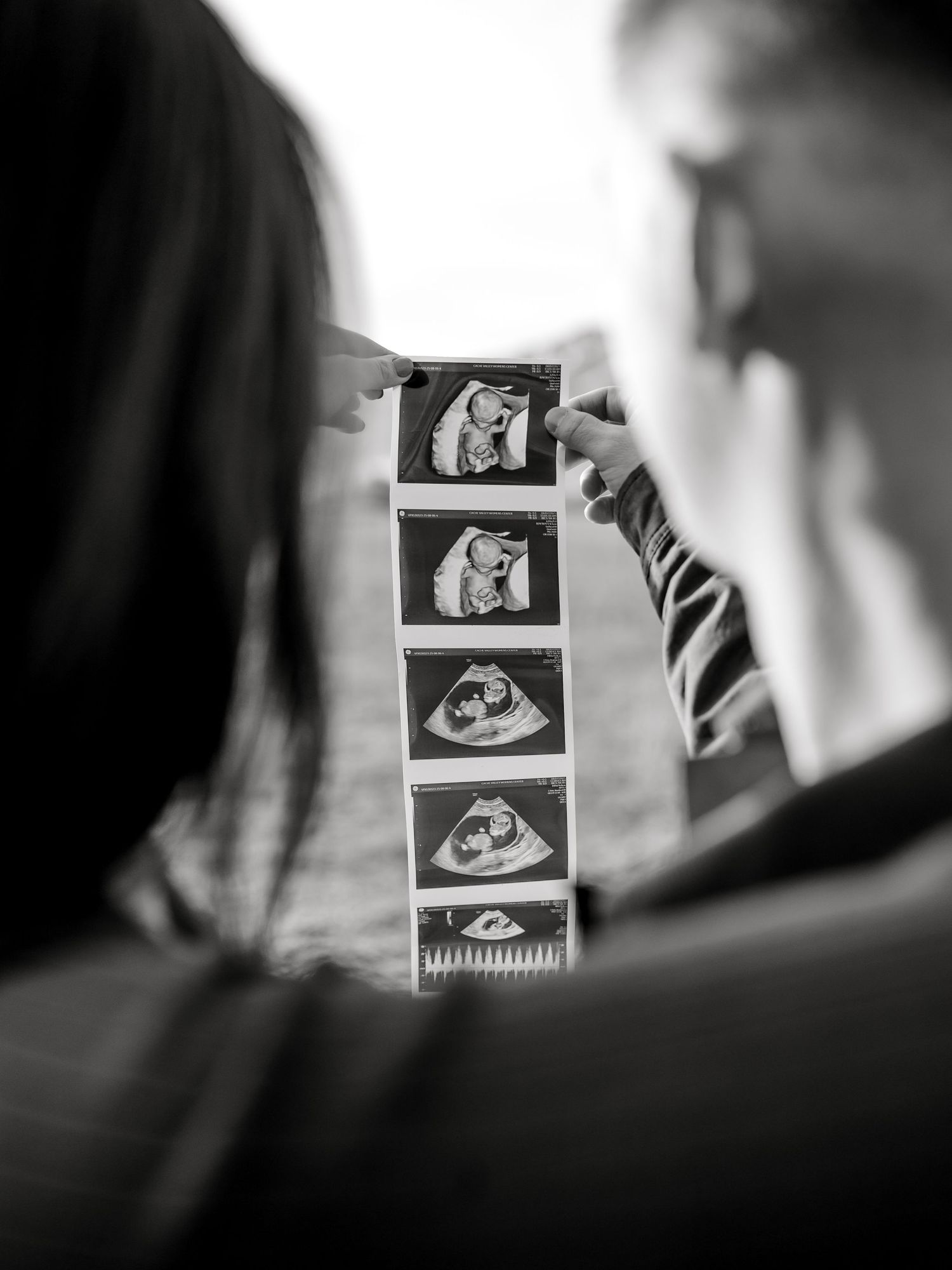 Utah Maternity Photos Maternity Photographer in Utah. Couple holding up ultrasound images of their unborn baby.