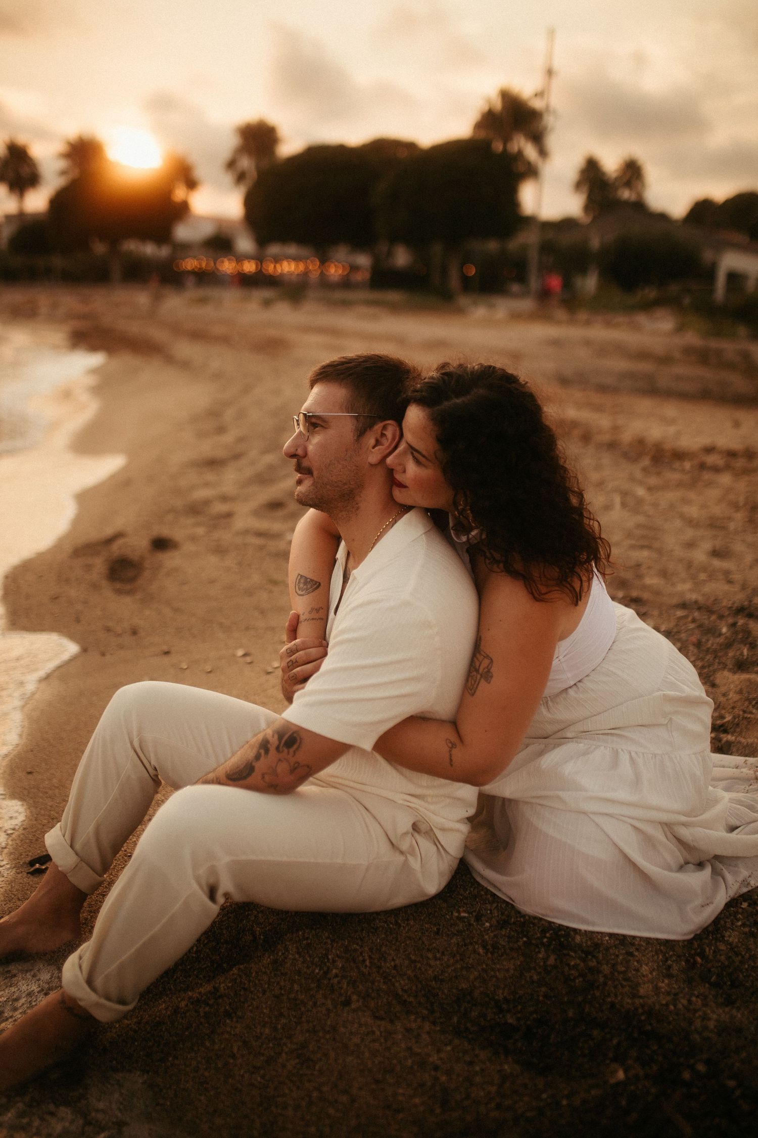 Novia abrazando al novio por detrás mientras miran al horizonte en sesión de boda en Tarragona