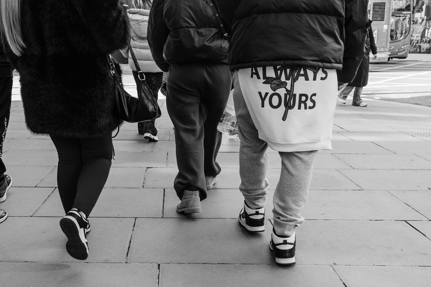 Black and white street photo showing a jumper saying "Always Yours"