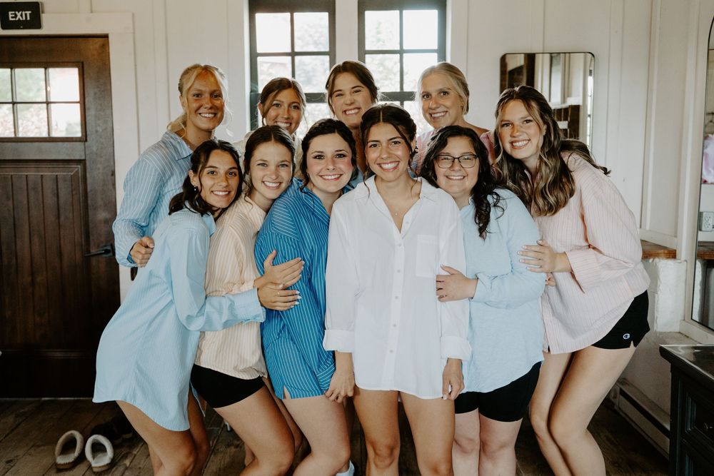 A group wearing matching light blue and white outfits poses together in a bright indoor setting.