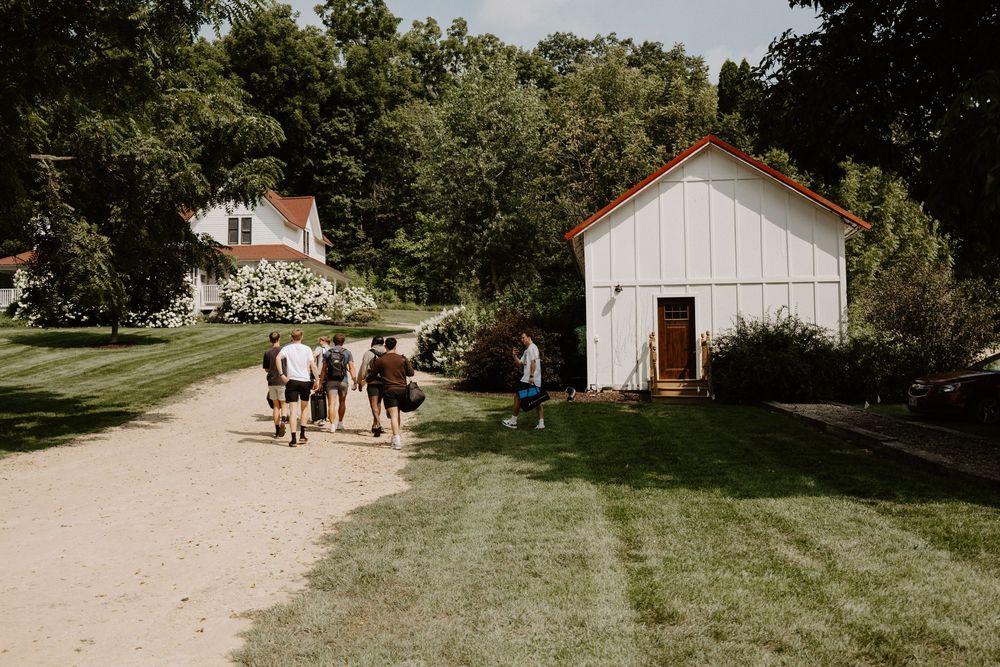 Scenic view of white farm buildings and barns nestled in lush green countryside.