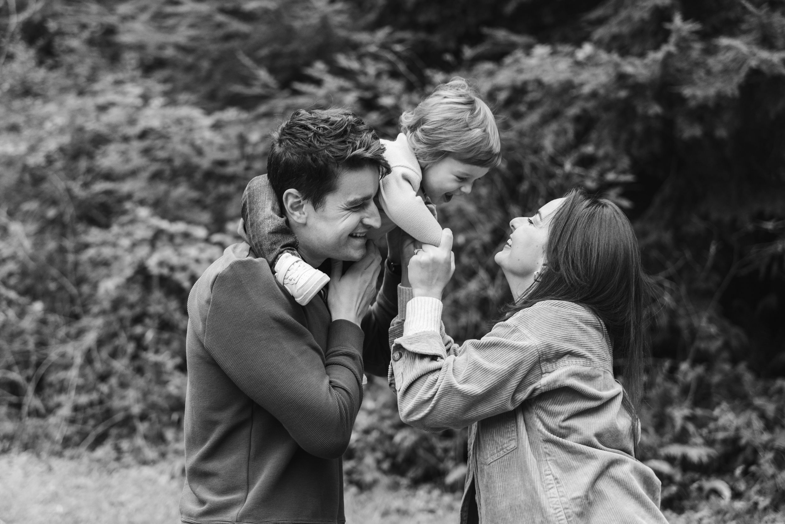 A romantic black and white photo series showing intimate moments between a couple in a natural outdoor setting.
