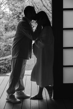 A series of three black and white silhouettes showing a couple in an intimate moment on a porch or deck.