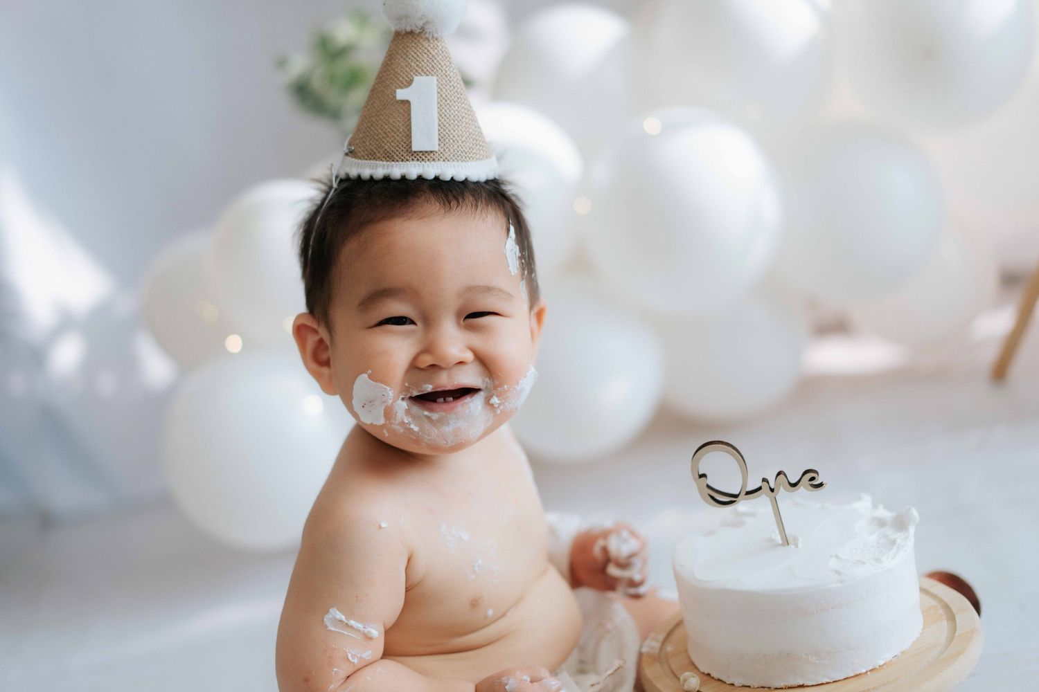 Adorable baby in a bathtub plays with soap bubbles and splashes during bath time.