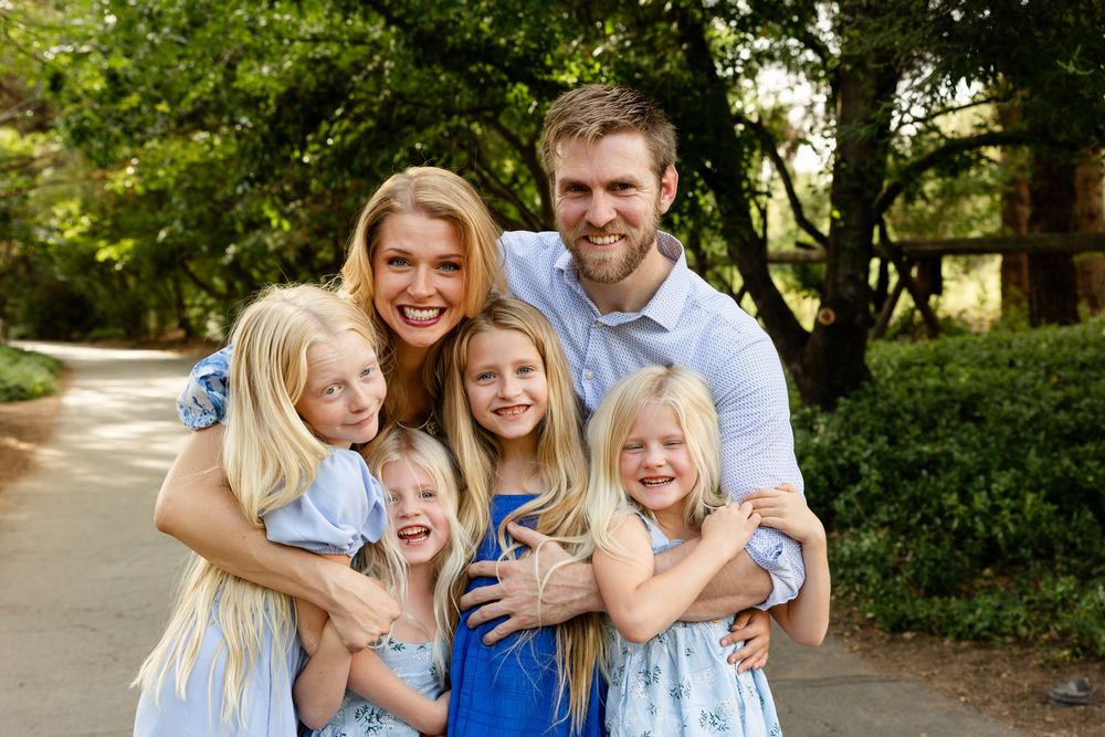 St. George utah family photos with 4 young girls smiling in a group hug at the camera