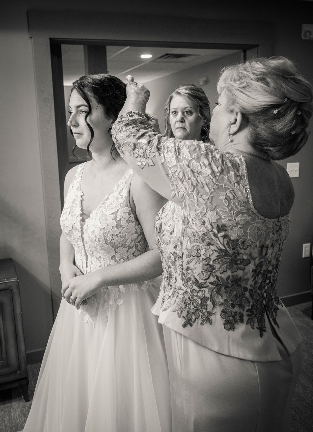 Black and white artistic photo of wedding dresses and lace details.
