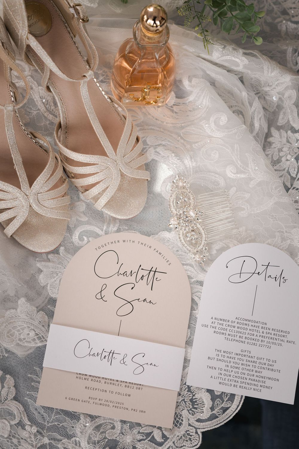 Wedding invitations and rings displayed on delicate lace with elegant calligraphy and soft lighting.