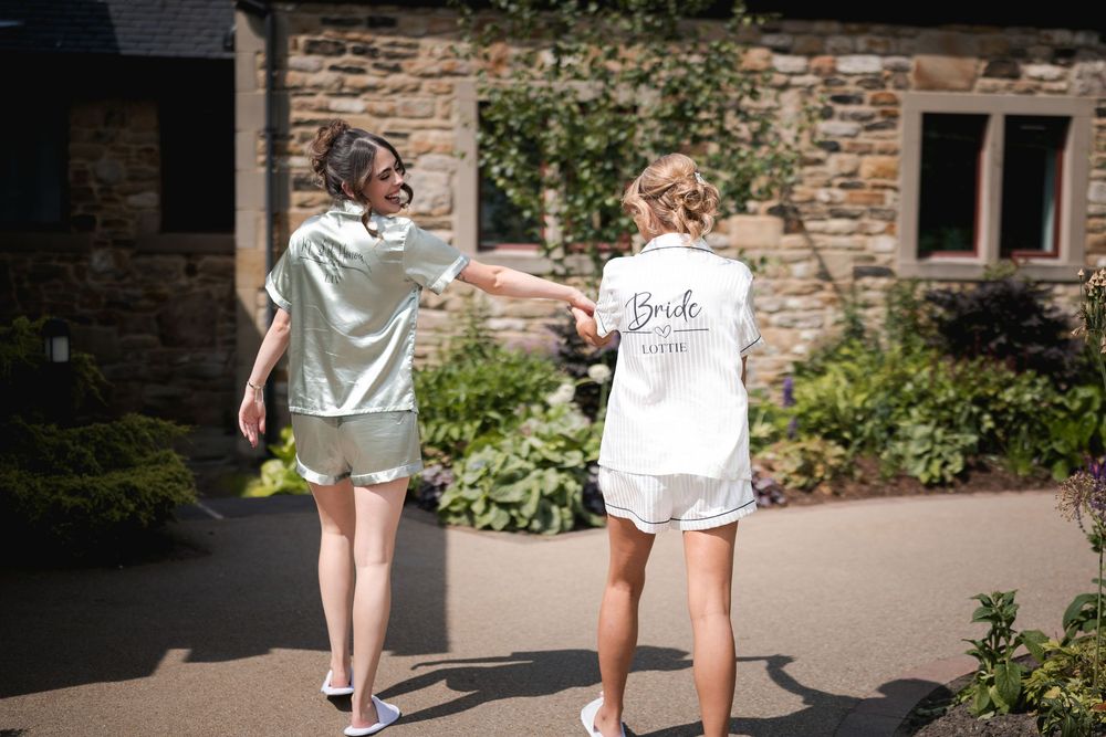 Wedding party walking through a sunny stone courtyard on a bright afternoon.
