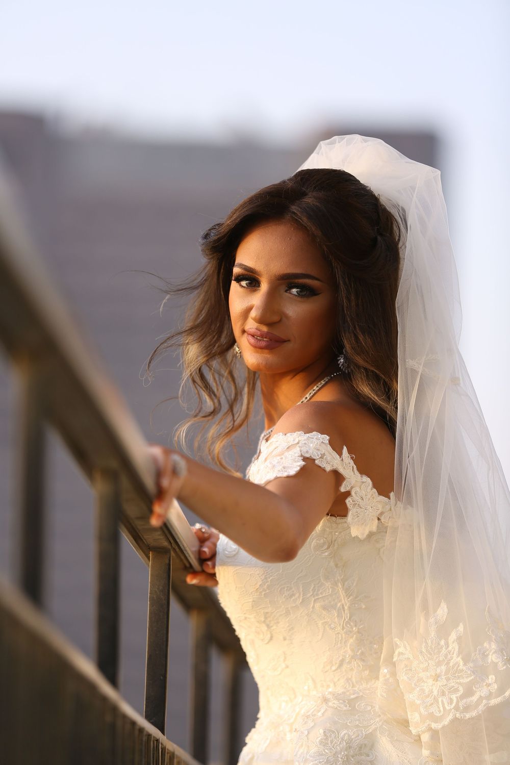 Elegant bridal portrait series featuring a white lace wedding dress and flowing veil.