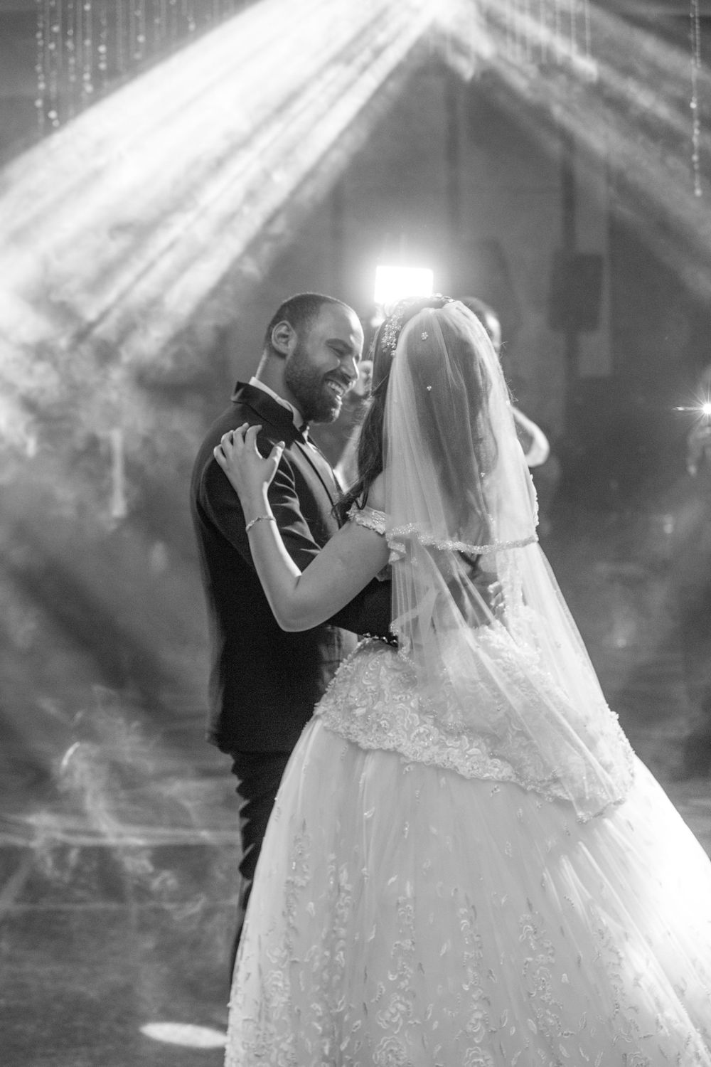 A romantic black and white wedding scene with dramatic lighting and streaming rays.