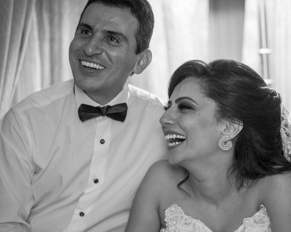 Black and white portrait of newlyweds sharing a joyful laughing moment together.