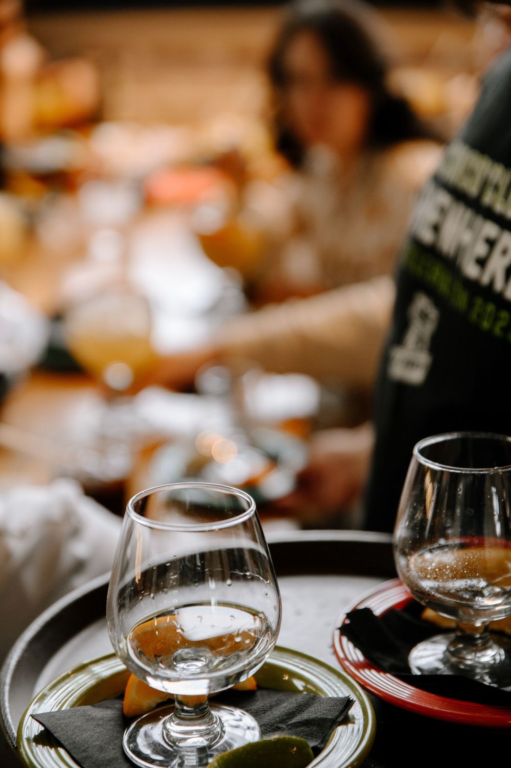 Close-up of wine glasses on a dark table during a restaurant tasting event.