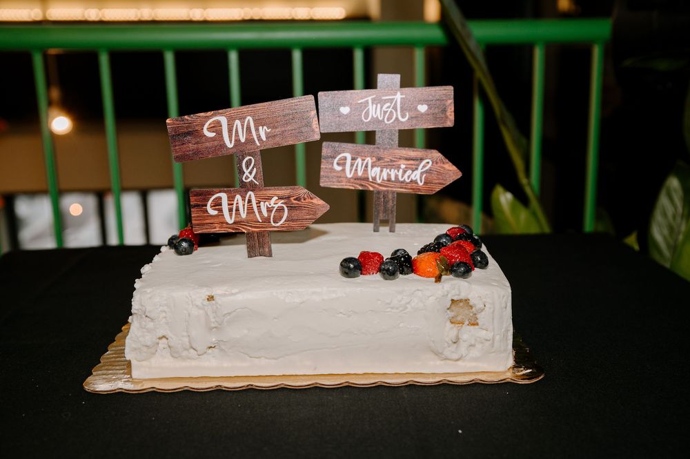 Small wooden decorative signs with berries and painted text displayed at what appears to be a rustic event or market.