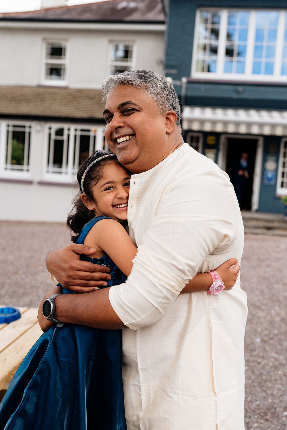 Four sequential photos show a heartwarming embrace between a parent and child in school uniform outside a building.