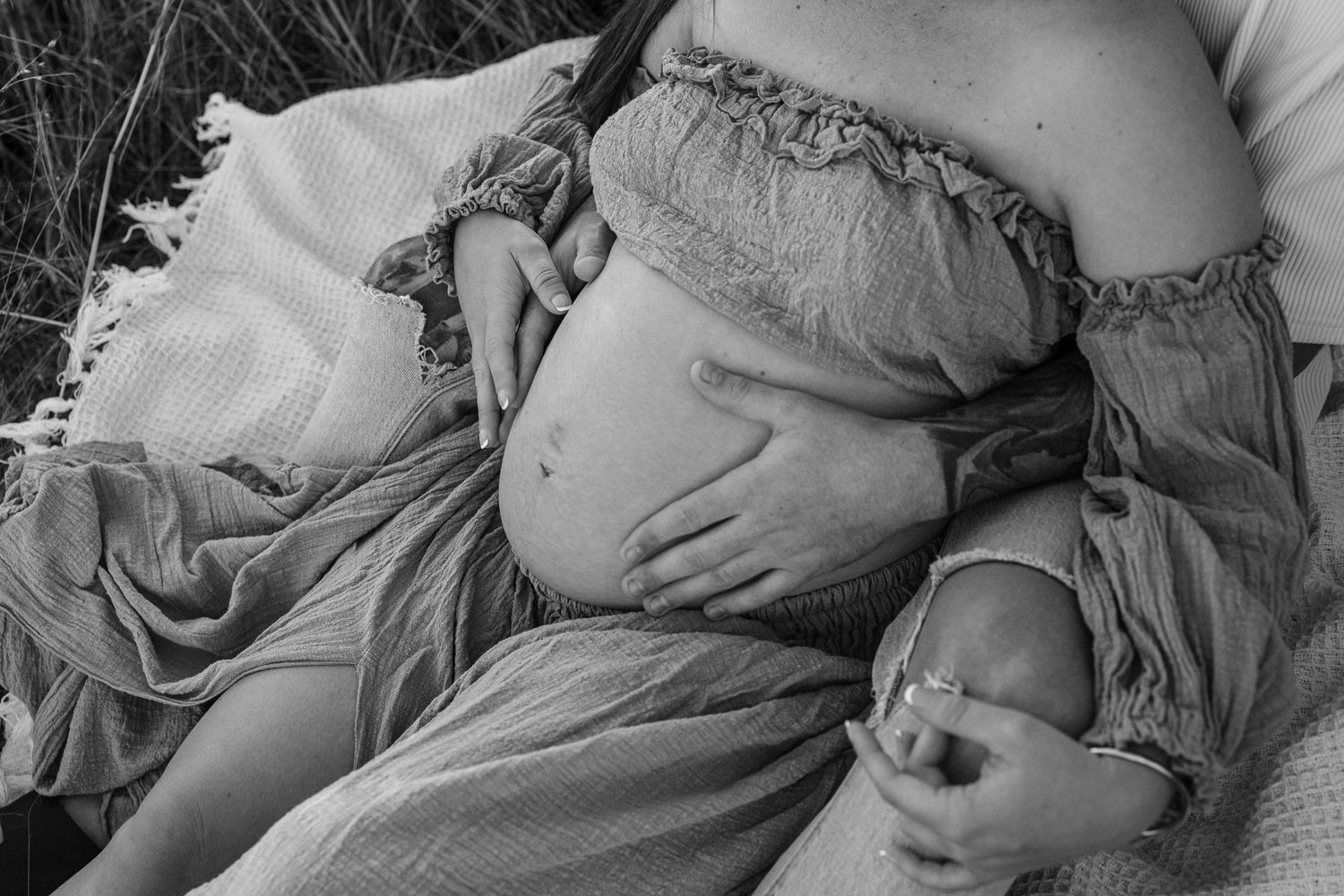 A black and white gallery of maternity photos showing a pregnant belly in various intimate poses.