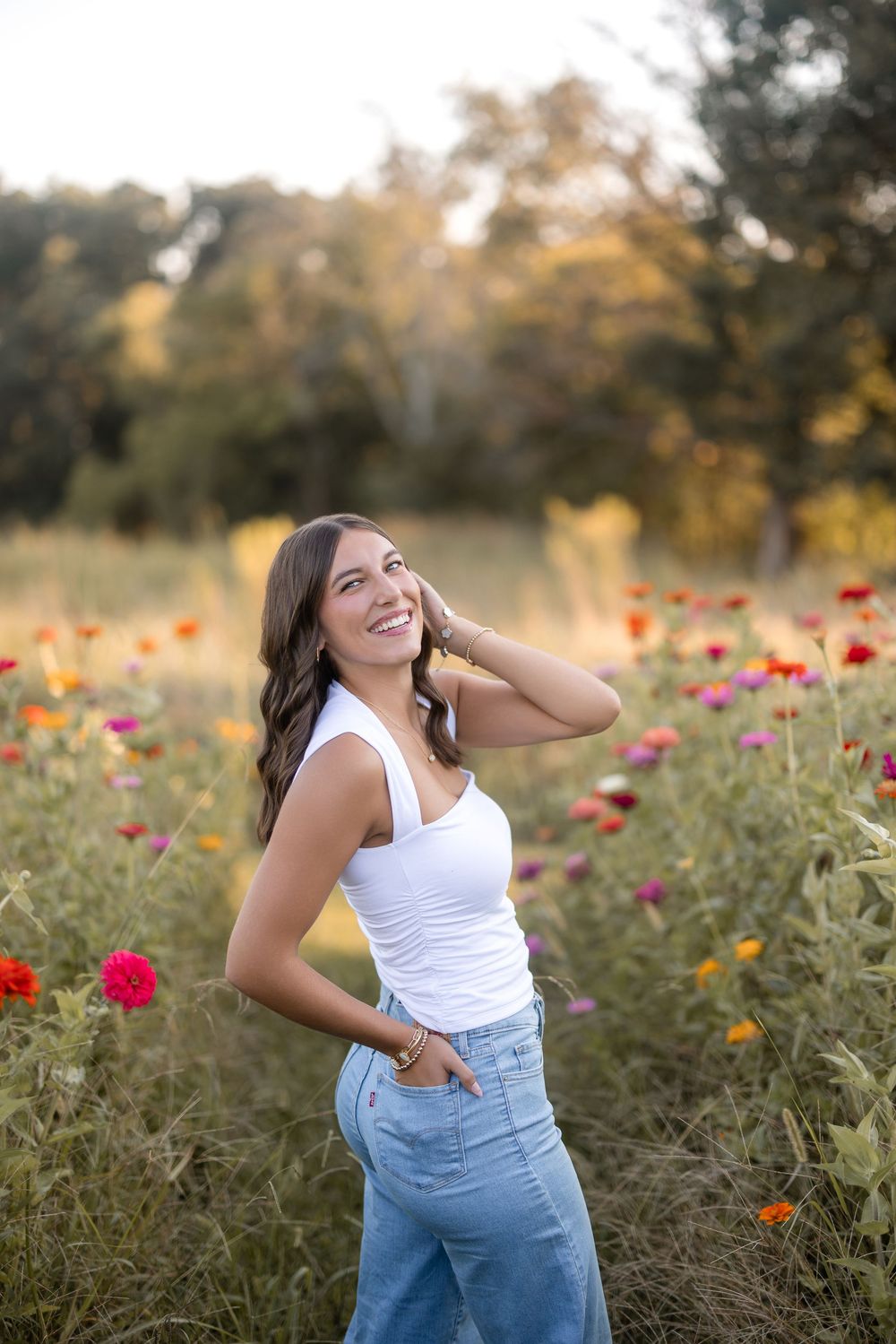 A joyful pose among colorful wildflowers and autumn foliage at sunset in a meadow.
