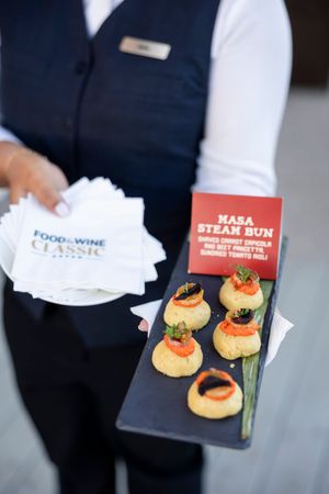 Appetizers served on white plates with food and wine pairing cards.