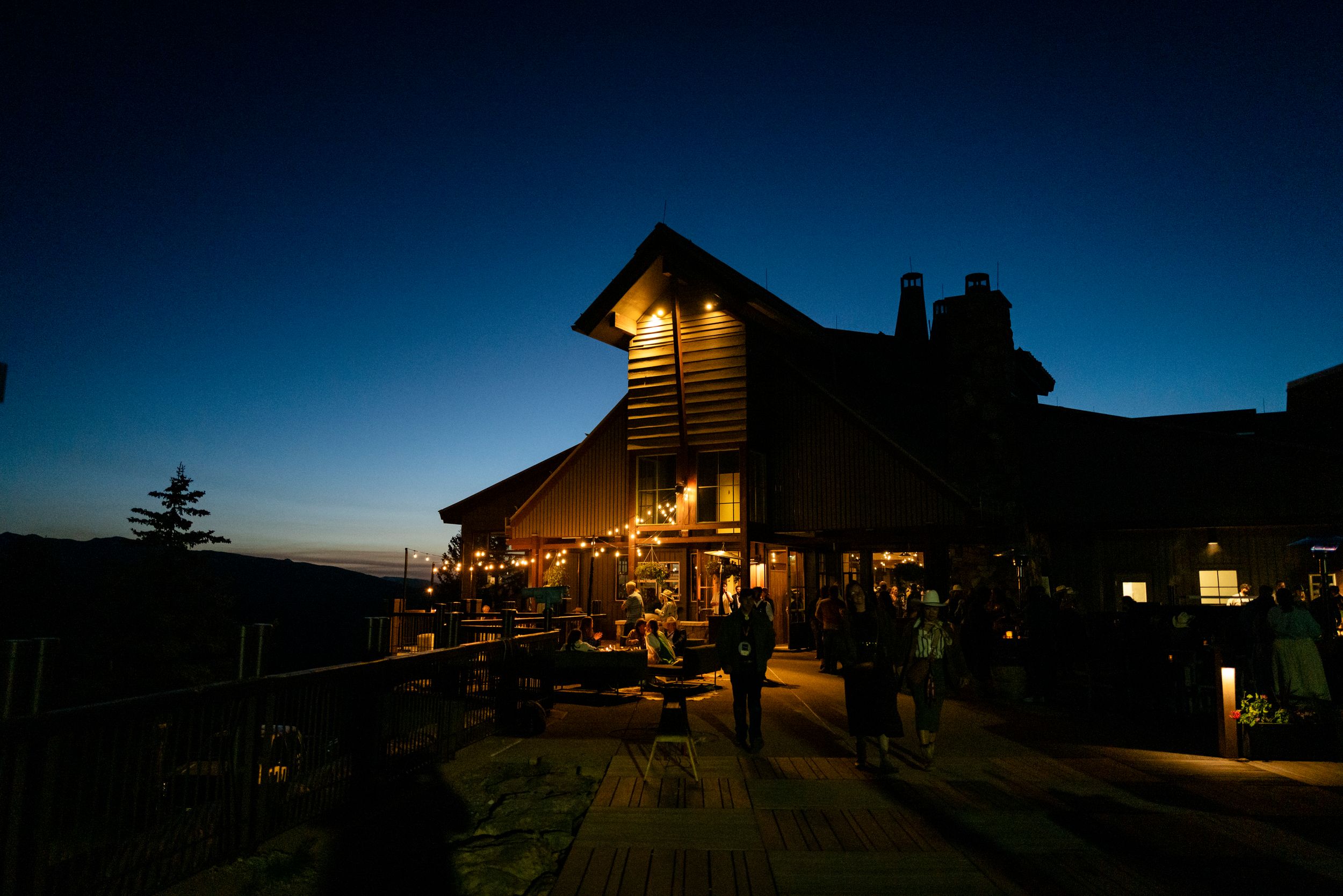 Log cabin homes illuminated at twilight against a deep blue sky.