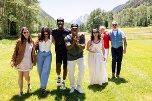 Group photo of attendees at outdoor summer event with mountains in background.